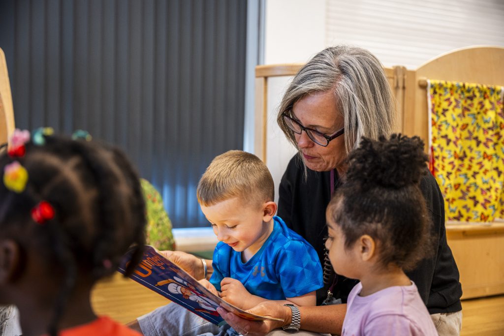 A teacher reading a story with a group of children