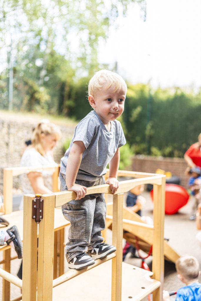 A child climbing on a climbing frame in the playground
