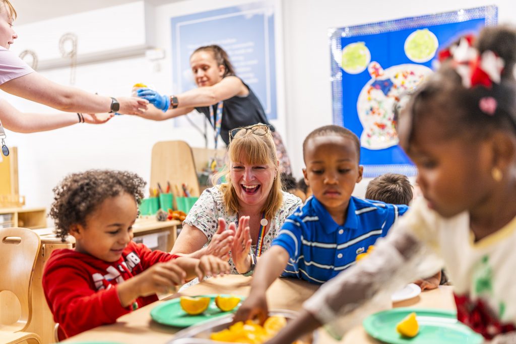 A classroom activity with teachers and children busy and laughing
